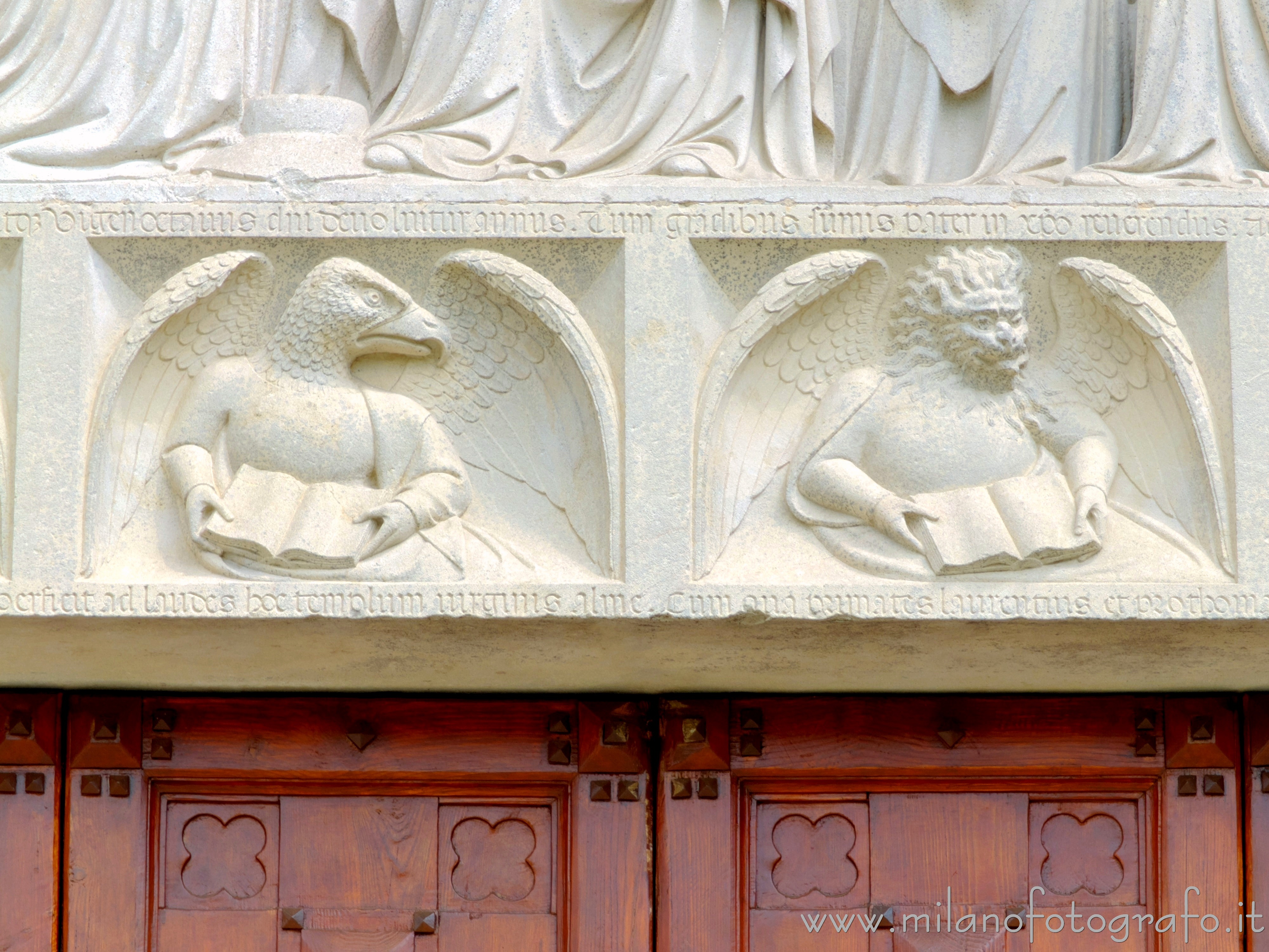 Castiglione Olona (Varese, Italy) - Symbols of Saint John and Saint Mark on the architrave of the portal of the Collegiate Church of Saints Stephen and Lawrence